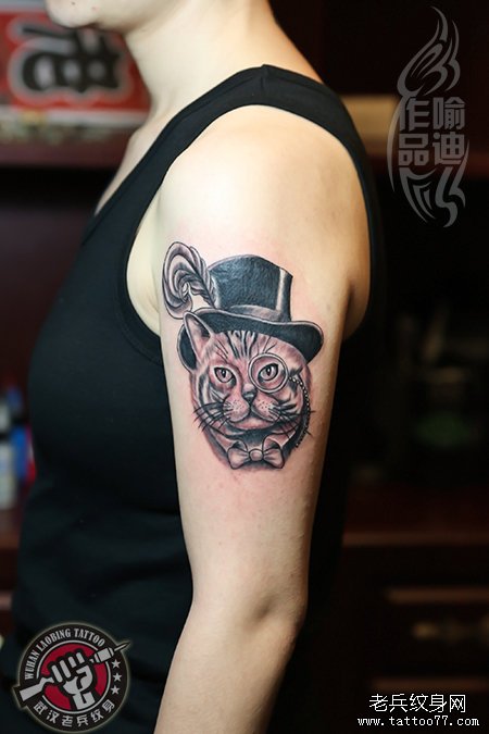 大臂戴帽子的猫子纹身作品遮盖字母图案