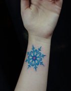 女生手腕处漂亮的彩色雪花纹身图案