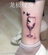 女生腿部潮流的一款红酒杯与小鸟纹身图案