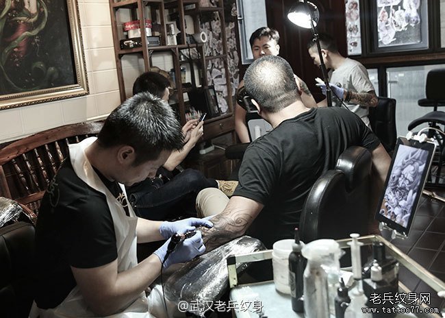 武汉纹身师兵哥和疯子为来自浙江的两位顾客纹身工作中