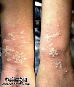 手臂时尚精美的白色雪花纹身图案