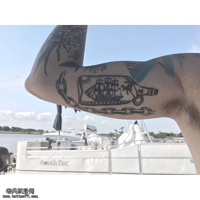 大臂上瓶子里的帆船纹身图案